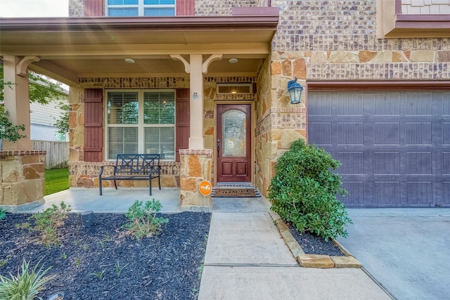 doorway to property with brick siding, a porch, and stone siding