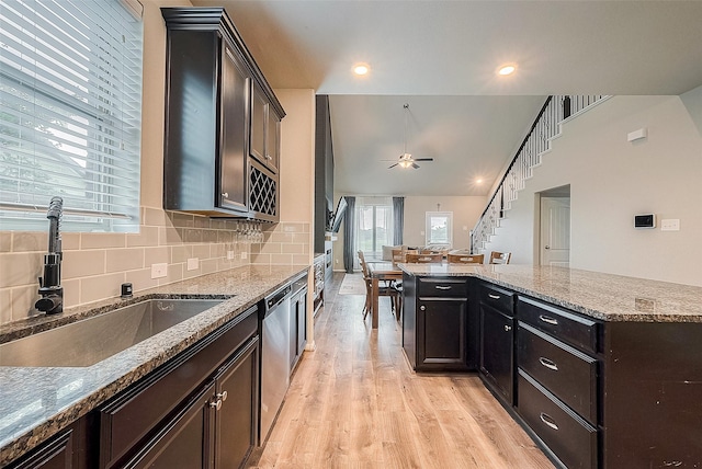 kitchen with stainless steel dishwasher, a sink, light wood-type flooring, tasteful backsplash, and ceiling fan