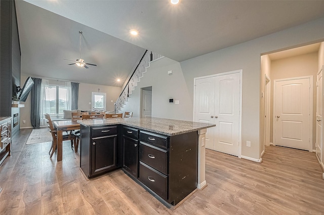 kitchen with ceiling fan, lofted ceiling, light wood finished floors, and baseboards