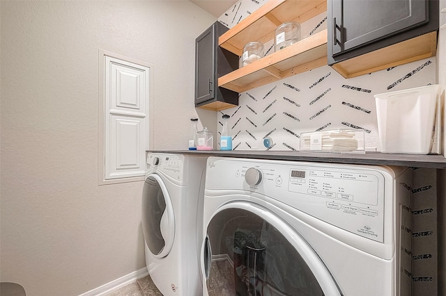 laundry room with washer and dryer, baseboards, and cabinet space