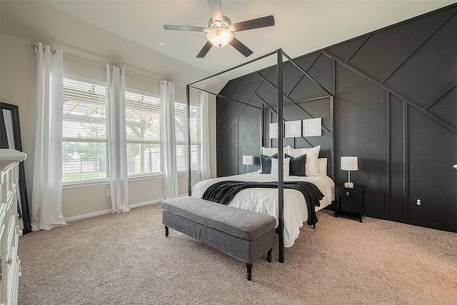 bedroom with light colored carpet, ceiling fan, baseboards, and lofted ceiling