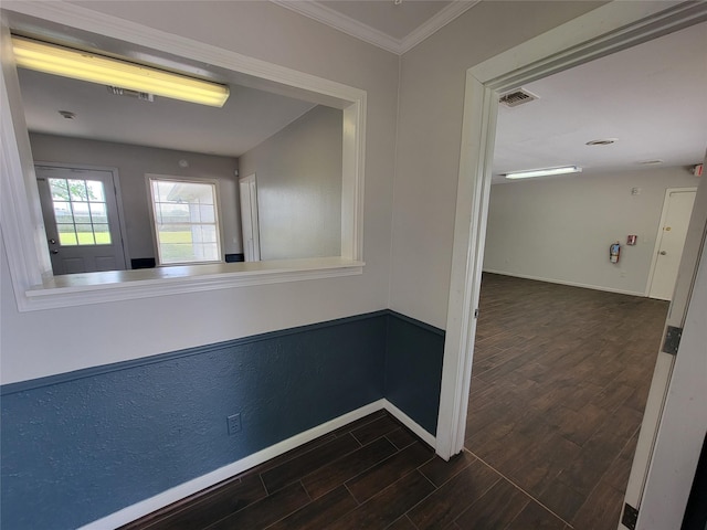 hallway featuring baseboards, ornamental molding, dark wood-type flooring, and visible vents