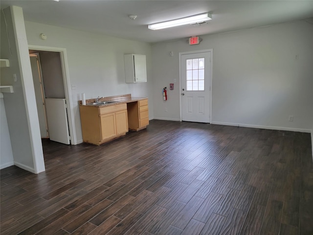 interior space with baseboards, dark wood-style floors, and a sink