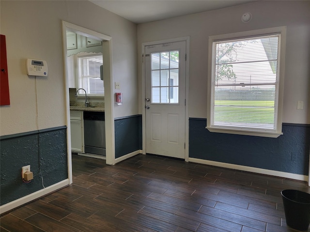 doorway with baseboards, dark wood-style floors, and a sink