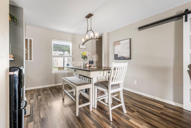 dining area with baseboards, dark wood-style floors, and a barn door