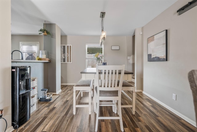 dining space featuring baseboards and wood finished floors