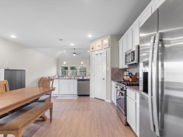 kitchen with white cabinets, appliances with stainless steel finishes, light wood finished floors, and recessed lighting
