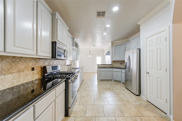 kitchen featuring a sink, visible vents, decorative backsplash, appliances with stainless steel finishes, and ornamental molding