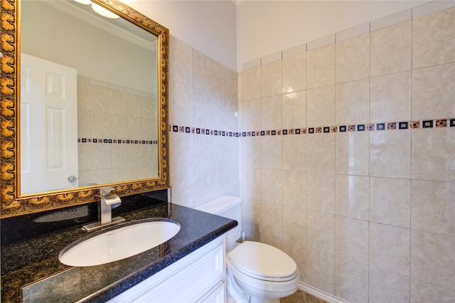 bathroom featuring tile walls, toilet, vanity, and crown molding