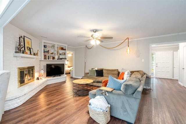 6226 Allentown Dr, Spring, TX 77389 - living area featuring wood finished floors, built in features, crown molding, ceiling fan, and a brick fireplace
