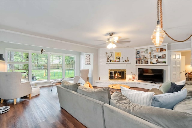 6226 Allentown Dr, Spring, TX 77389 - living area with a brick fireplace, dark wood-type flooring, ceiling fan, and crown molding