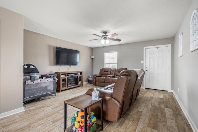 living room with baseboards, ceiling fan, and wood finished floors