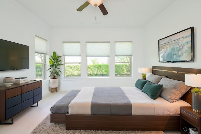 bedroom featuring light wood-style flooring, a ceiling fan, and crown molding