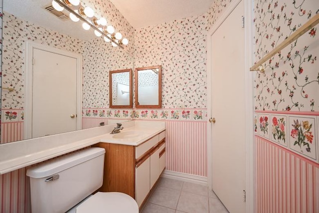 bathroom with wallpapered walls, tile patterned flooring, visible vents, toilet, and vanity