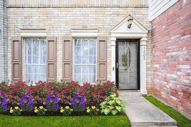 doorway to property featuring brick siding