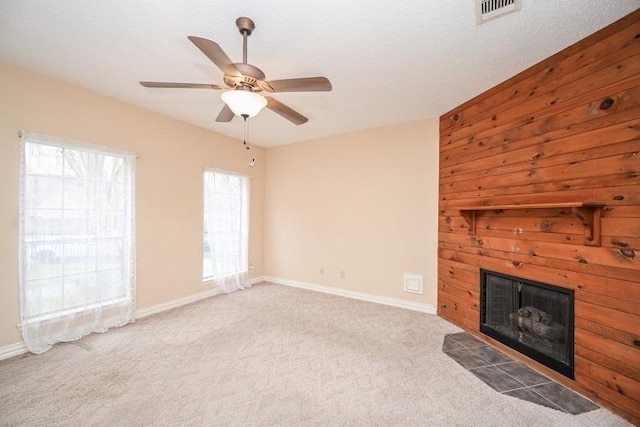 unfurnished living room with a fireplace with flush hearth, carpet, visible vents, and baseboards