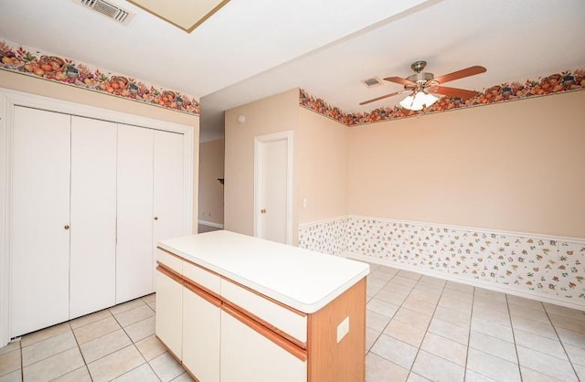 kitchen featuring light countertops, visible vents, light tile patterned floors, a center island, and ceiling fan