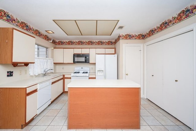 kitchen with a sink, white appliances, light tile patterned floors, light countertops, and a kitchen island