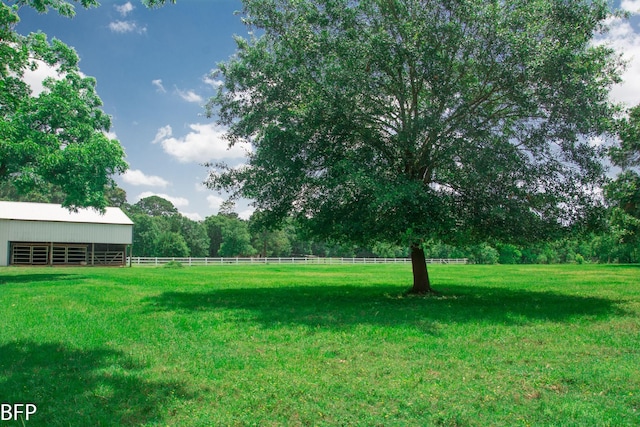 view of yard featuring fence, an outbuilding, and a pole building