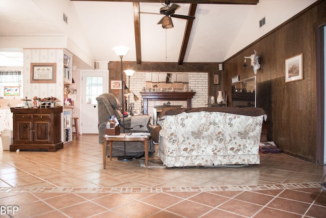 tiled living area with a ceiling fan, high vaulted ceiling, wood walls, and visible vents