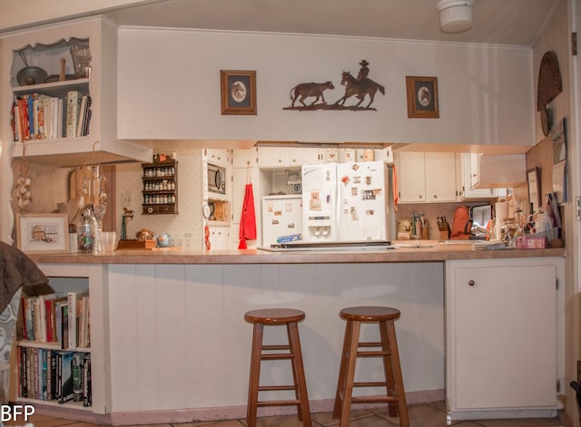 kitchen featuring crown molding, white fridge with ice dispenser, tasteful backsplash, and white cabinetry