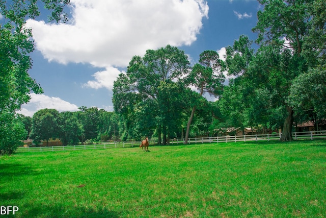 view of yard with a rural view and fence