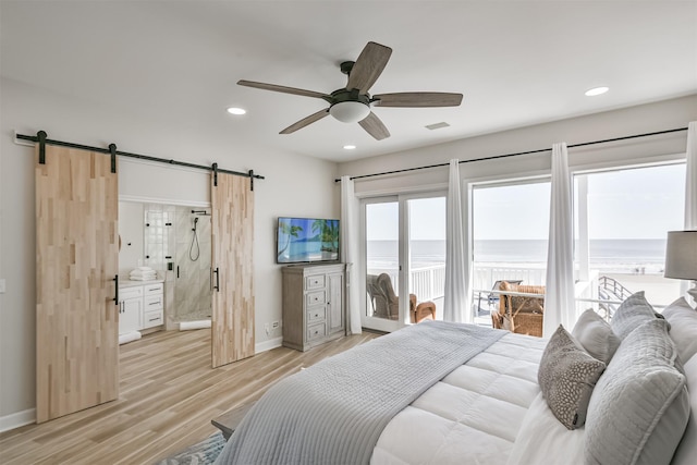bedroom featuring a barn door, access to outside, baseboards, light wood-style flooring, and recessed lighting