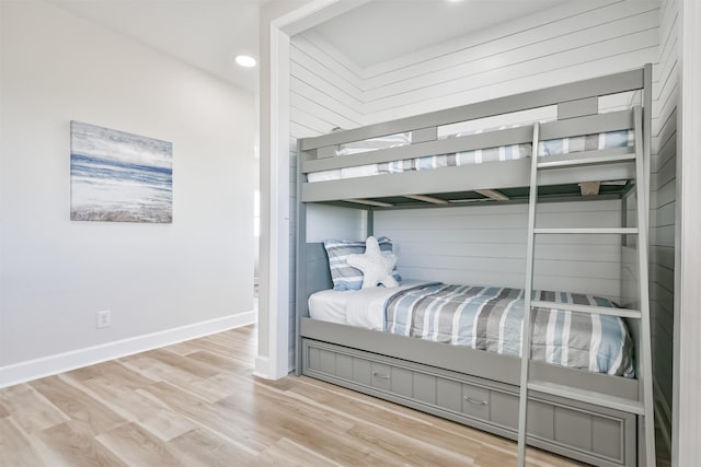 bedroom featuring baseboards, wood finished floors, and recessed lighting