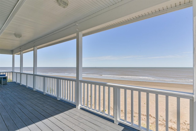 wooden terrace featuring view of water and beach
