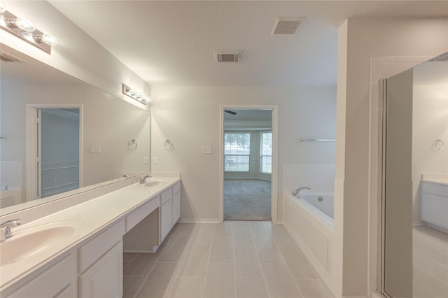 full bath with double vanity, visible vents, a sink, and a garden tub