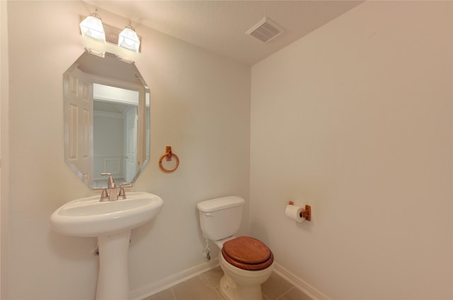 bathroom featuring baseboards, tile patterned flooring, toilet, and visible vents