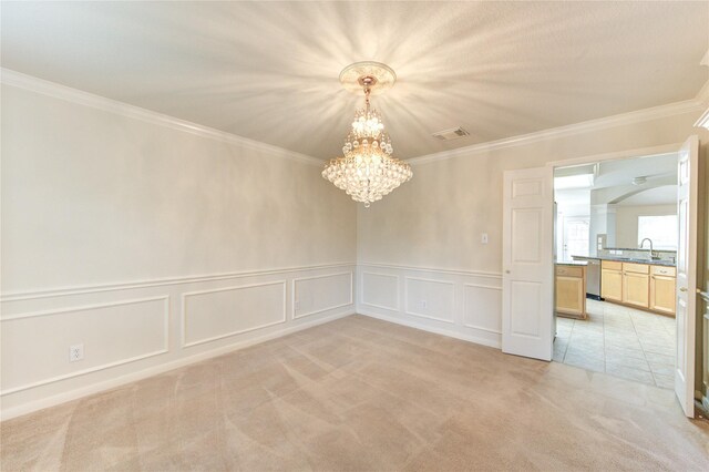 unfurnished room featuring light colored carpet, crown molding, a notable chandelier, and visible vents