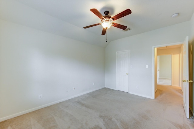 unfurnished bedroom featuring light carpet, a ceiling fan, baseboards, lofted ceiling, and visible vents