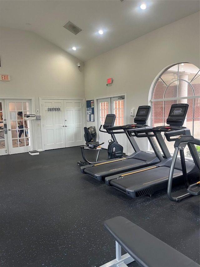 gym with french doors, recessed lighting, a wealth of natural light, and high vaulted ceiling