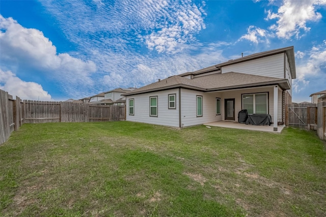 back of property with a fenced backyard, a yard, a patio, and a shingled roof