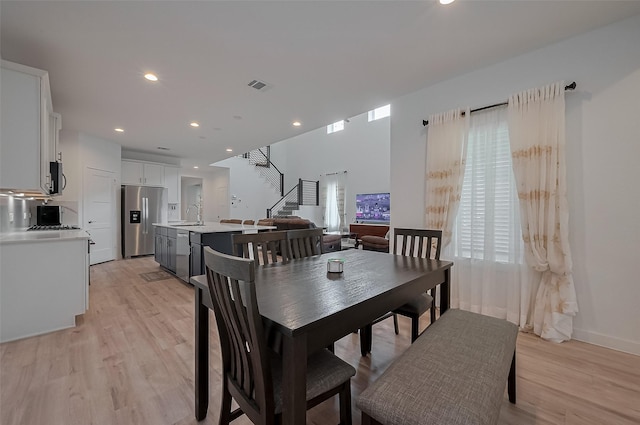 dining area with recessed lighting, light wood-type flooring, visible vents, and stairs