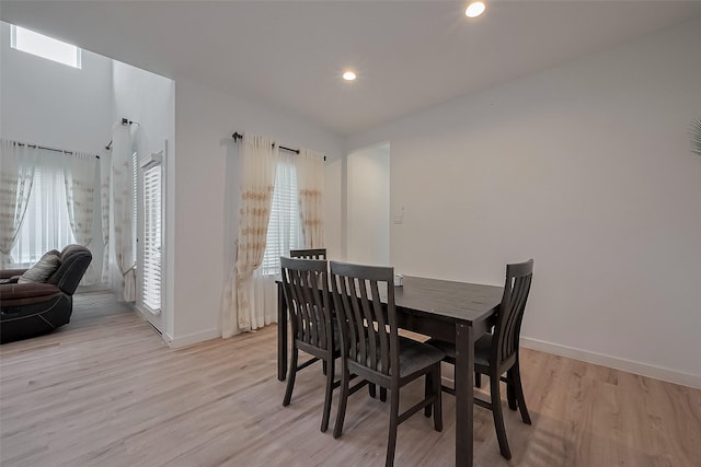 dining area with baseboards, a wealth of natural light, and light wood-type flooring