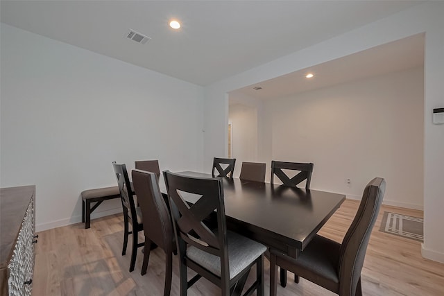 dining space with baseboards, light wood-style flooring, and visible vents