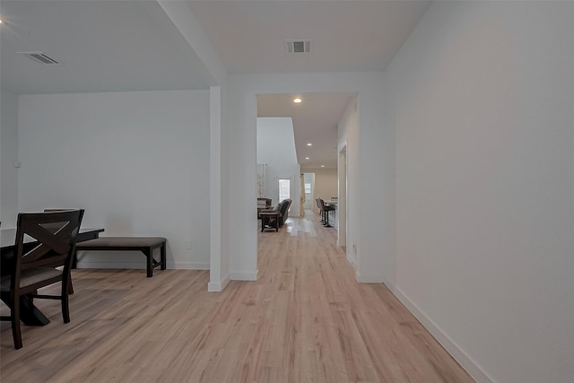 corridor with light wood finished floors, baseboards, visible vents, and recessed lighting