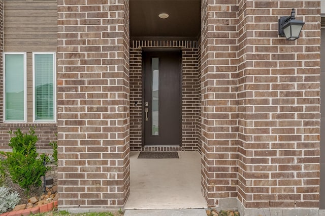 property entrance with elevator and brick siding
