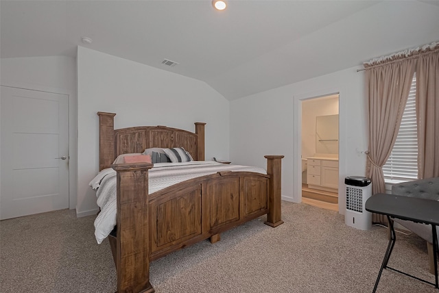 bedroom featuring vaulted ceiling, visible vents, ensuite bathroom, and light colored carpet