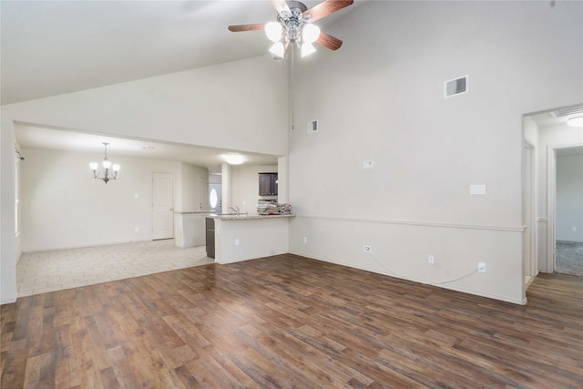 7218 Alava Dr, Magnolia, TX 77354 - unfurnished living room with high vaulted ceiling, wood finished floors, a chandelier, a ceiling fan, and a sink