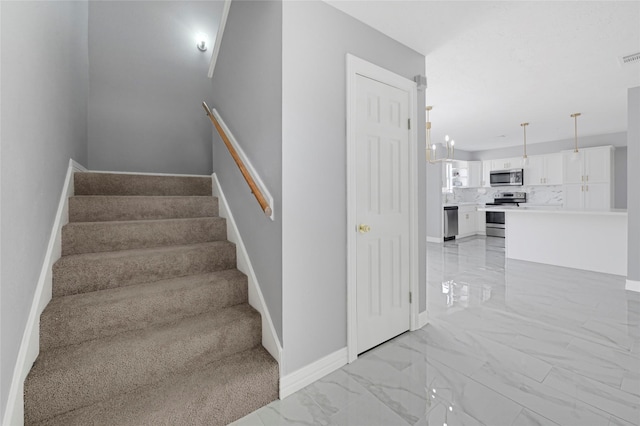 staircase featuring baseboards and marble finish floor