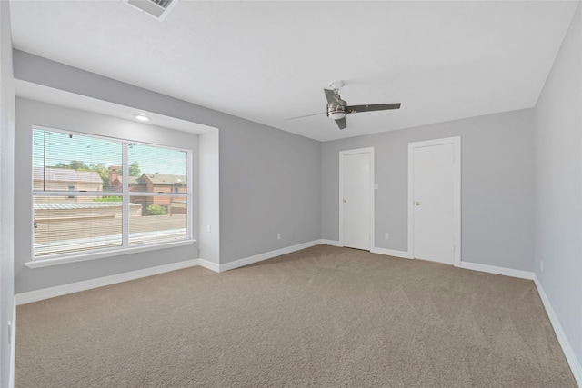 unfurnished bedroom featuring ceiling fan, multiple closets, carpet, baseboards, and visible vents