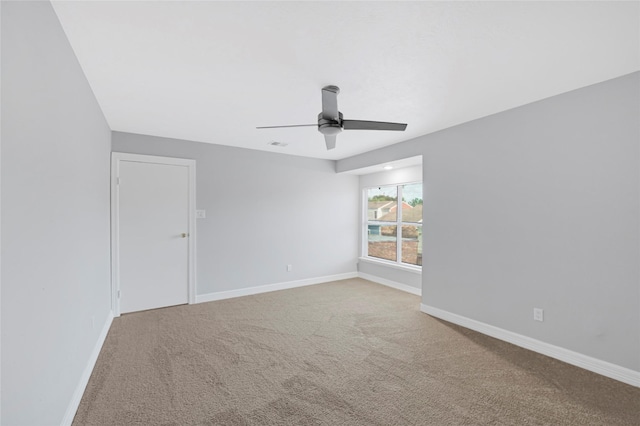 empty room featuring baseboards, a ceiling fan, and carpet flooring