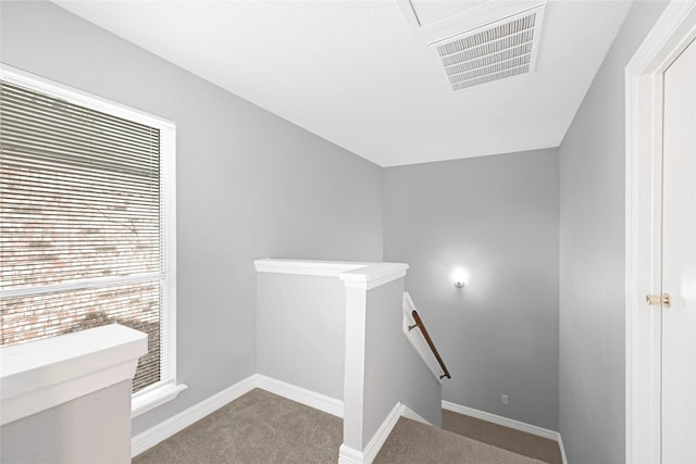 stairway with visible vents, carpet flooring, and baseboards
