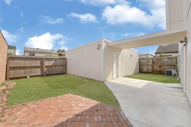 view of yard with an outdoor structure, central AC, a fenced backyard, and a patio area