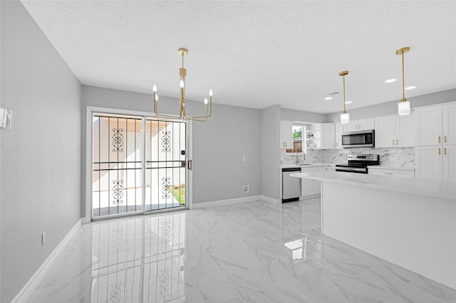 kitchen with marble finish floor, light countertops, white cabinetry, a sink, and stainless steel appliances