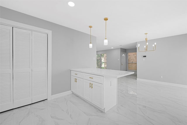 kitchen featuring an inviting chandelier, hanging light fixtures, marble finish floor, a peninsula, and white cabinetry