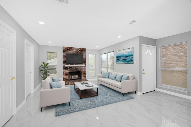 living room featuring visible vents, marble finish floor, a healthy amount of sunlight, and a fireplace
